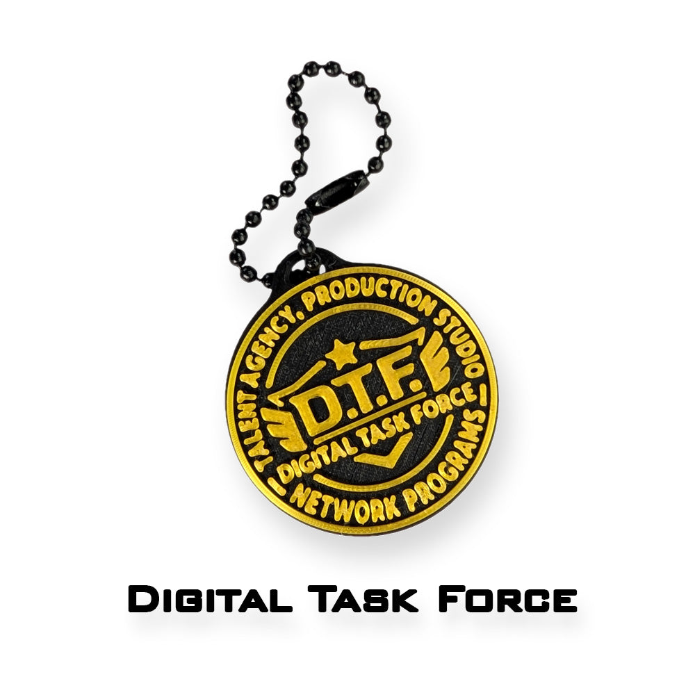 A round black and gold keychain or bag charm with a black ball chain, featuring the 'Digital Task Force' logo and text, shown on a white background with 'DIGITAL TASK FORCE' printed below.